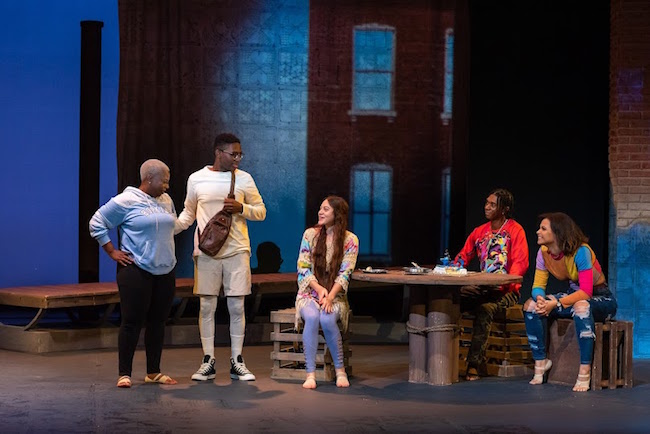 Characters in The Black Reps production of 'Dontrell, Who Kissed the Sea,' gathered around a table, photo by Philip Hamer.